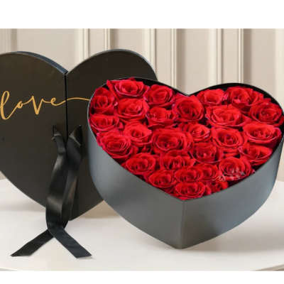 Heart-shaped box of red roses with a black lid reading love