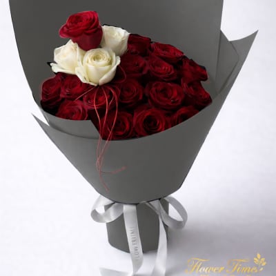 Bouquet of red and white roses wrapped in gray paper