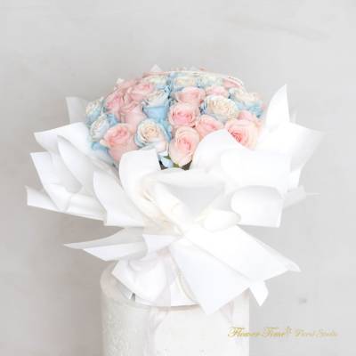 Bouquet of pastel pink and blue roses wrapped in white paper