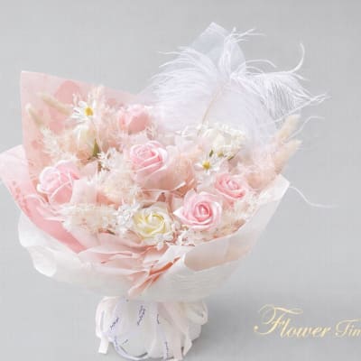 Pink and white rose bouquet with feathers and sheer wrapping
