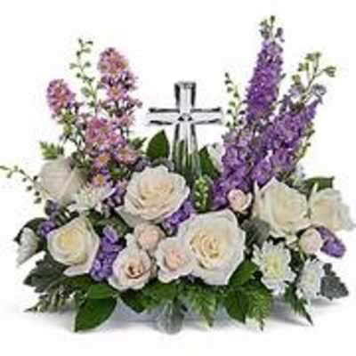 White and purple floral arrangement with a cross centerpiece