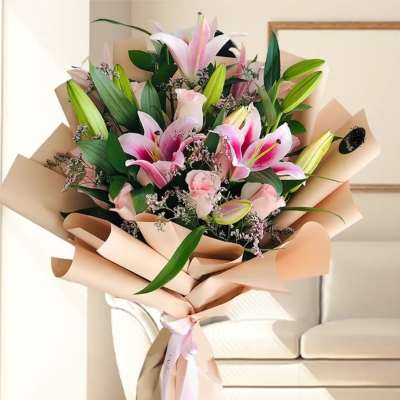 Bouquet of pink lilies and roses wrapped in beige paper