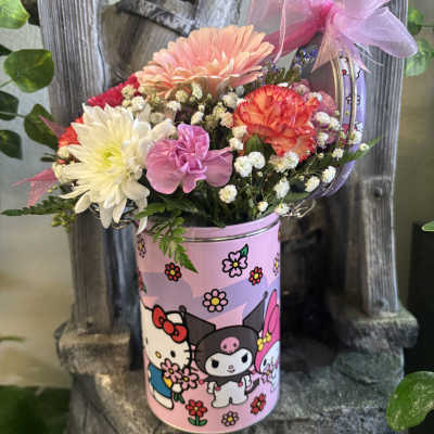 Pink floral arrangement in a Hello Kitty tin with a ribbon bow
