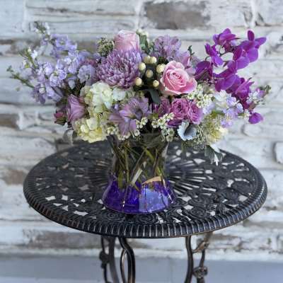 Lavender and pink bouquet in a purple glass vase