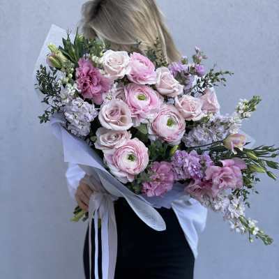 Woman holding a large bouquet of pink and white flowers