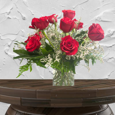 Red roses arranged in a clear glass vase