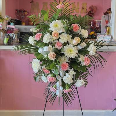 Standing floral spray with pink and white flowers on a metal easel