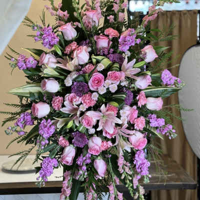 Large pink and purple floral standing spray with roses and lilies