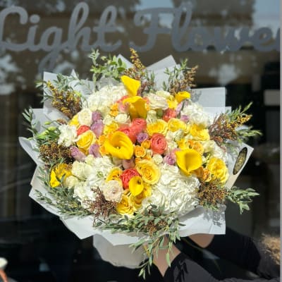 Large bouquet of yellow calla lilies, roses, and white hydrangeas
