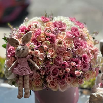 Pink rose bouquet in a round pink box with a crocheted bunny doll