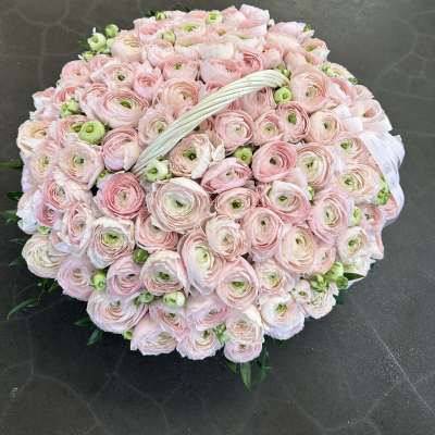 Large round bouquet of pale pink ranunculus with a white handle