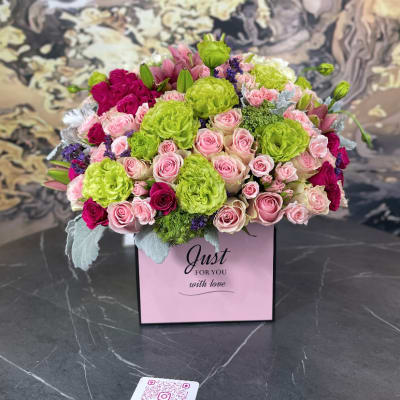 Pink and lime green rose arrangement in a gift box