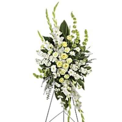 Tall white and pale yellow funeral spray on a stand