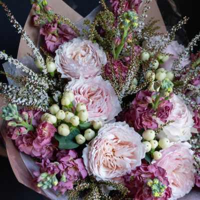 Bouquet of pale pink roses and purple flowers with white berries