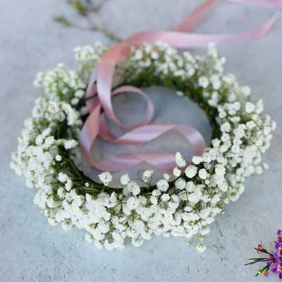 White baby's breath floral wreath with a pink ribbon