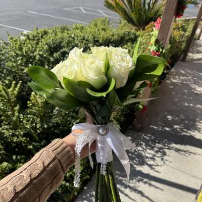 Handheld bouquet of white roses with a lace ribbon bow