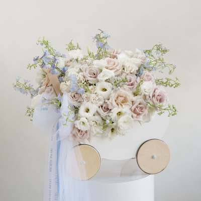 Pastel bouquet of roses and white blooms with blue accents