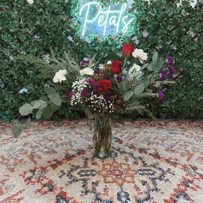 Tall bouquet of red and white roses in a glass vase