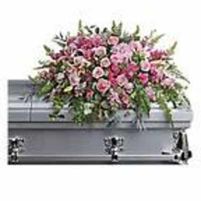 Pink and white floral casket spray on a gray casket
