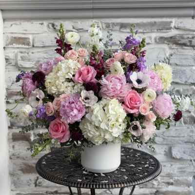 Pink and white mixed flower arrangement in a white vase