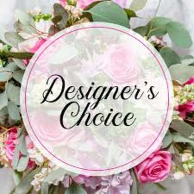 Pink and white floral arrangement with a round "Designer’s Choice" sign