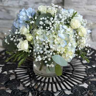 Blue and white floral arrangement in a glass vase