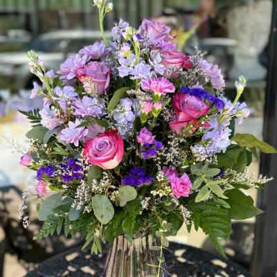 Bouquet of pink roses and lavender flowers in a glass vase