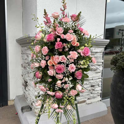 Tall pink floral standing spray on an easel
