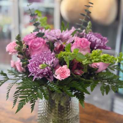 Pink and purple mixed bouquet in a textured glass vase