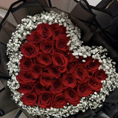 Heart-shaped bouquet of red roses with white baby's breath