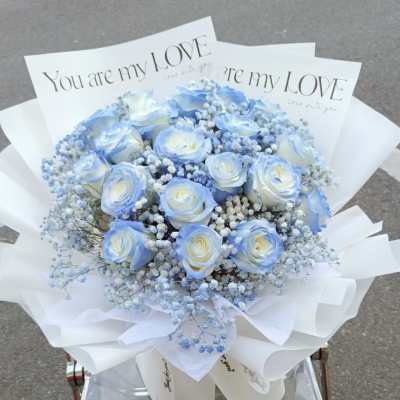 Blue and white rose bouquet with baby's breath in white wrap