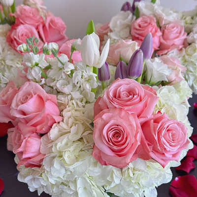 Pink roses and white hydrangeas with purple tulips in a glass vase