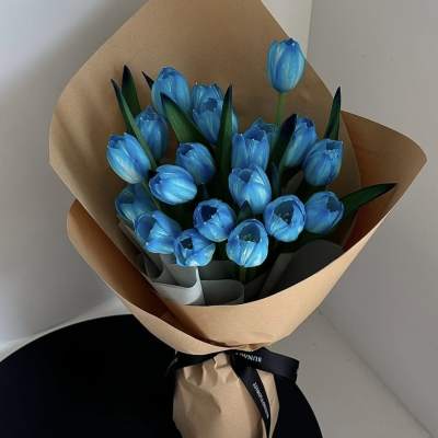 Bouquet of bright blue tulips wrapped in brown paper