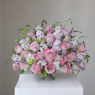 Pink rose bouquet with lavender filler flowers in a low vase