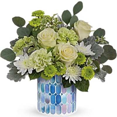 Compact mix of white roses, green carnations, and mums in a blue mosaic cylinder vase