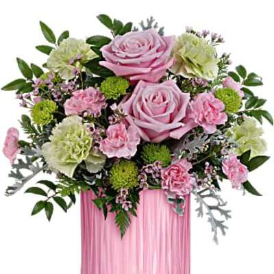 Pink roses, green carnations, and mixed blooms in a ribbed pink glass cylinder vase