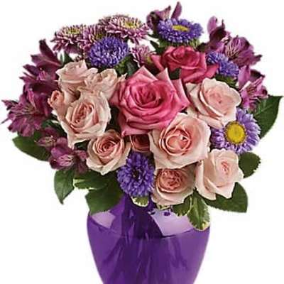 Pink roses and purple asters arranged in a glossy purple vase