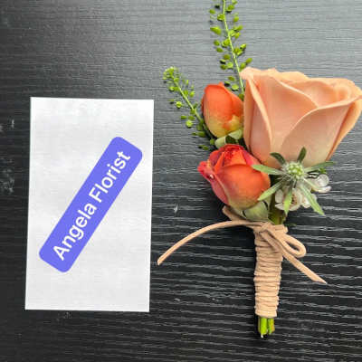Small boutonniere with peach and orange roses tied with twine