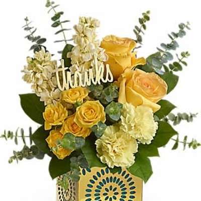 Yellow roses, carnations, and small yellow blooms in a yellow patterned cube with a thanks sign