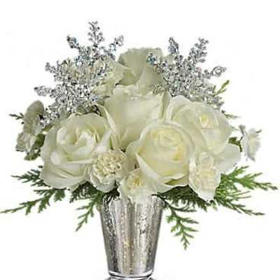 Compact arrangement of white roses and blooms with silver snowflakes in a silver vase