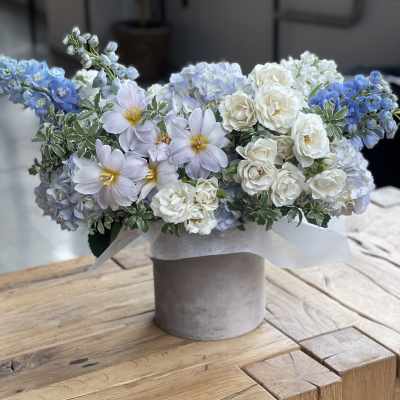 Blue and white floral arrangement in a gray vase