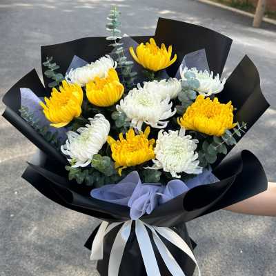 Bouquet of yellow and white chrysanthemums wrapped in black paper