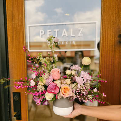Mixed pink and white flower arrangement in a small ceramic vase