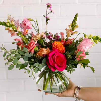 Mixed pink and orange flower arrangement in a glass vase