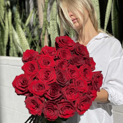 Woman holding a large bouquet of red roses