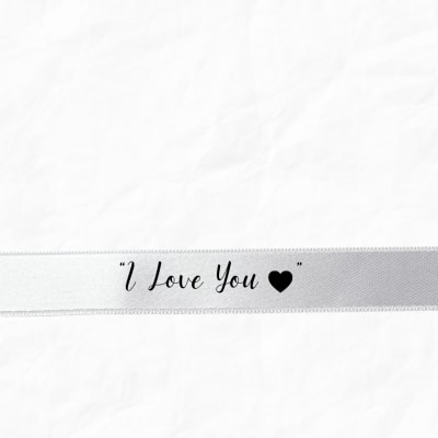 White ribbon with the words "I Love You" and a heart