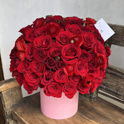 Large bouquet of red roses in a pink cylindrical box