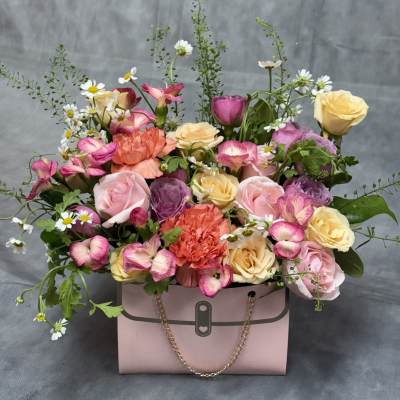 Pink gift box filled with roses, carnations, and daisies