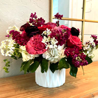 Bouquet of pink and burgundy flowers in a white vase