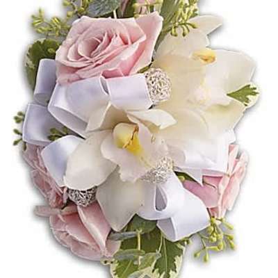 Corsage of pale pink roses and white orchids with white ribbon and greenery.
